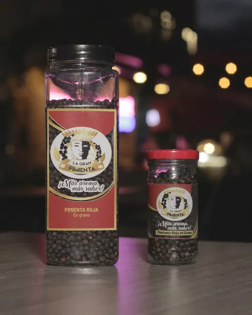 Frasco grande y frasco pequeño de pimienta roja entera, en grano